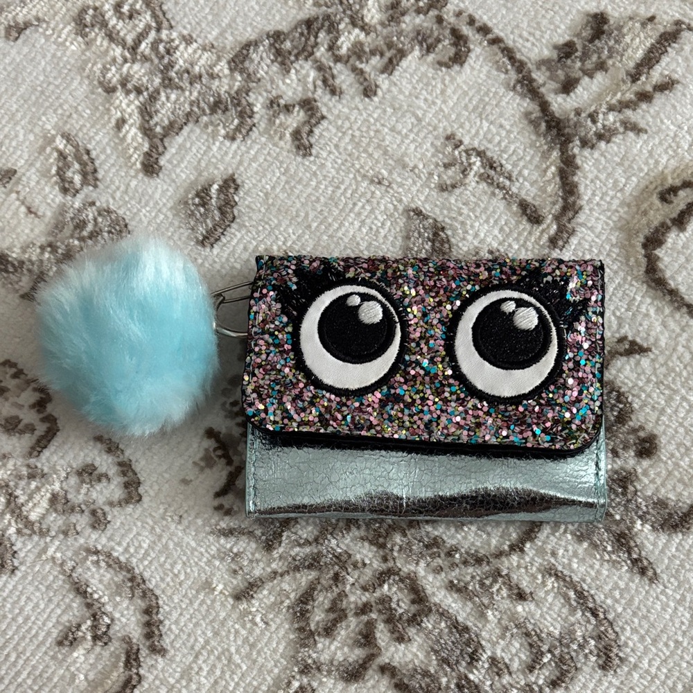 Justice Glittery Eye Wallet with Blue Pom Pom